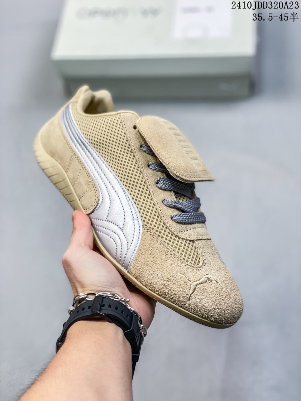 Angled view of the beige sneaker with silver side stripe and mesh panels.