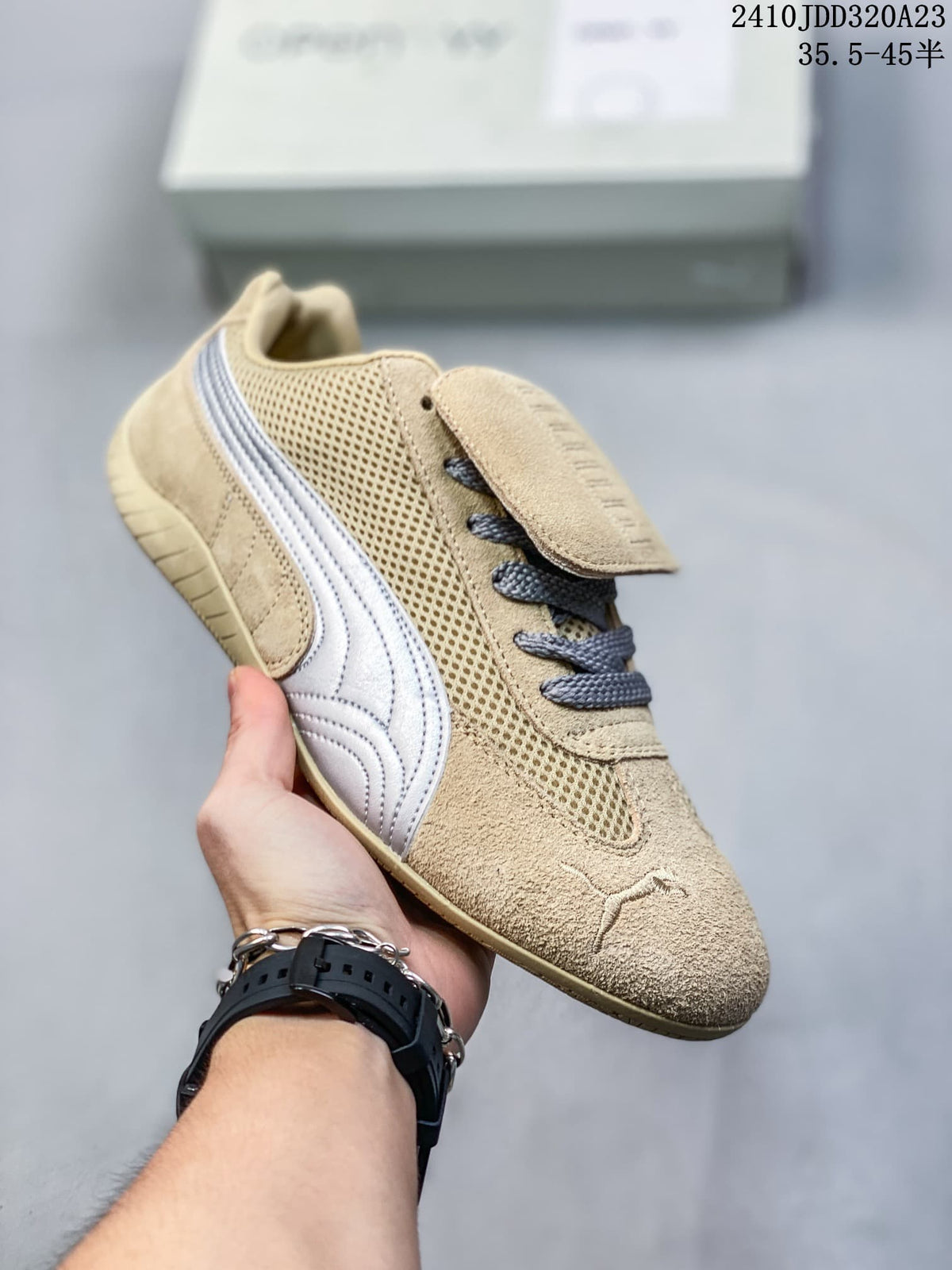 Angled view of the beige sneaker with silver side stripe and mesh panels.