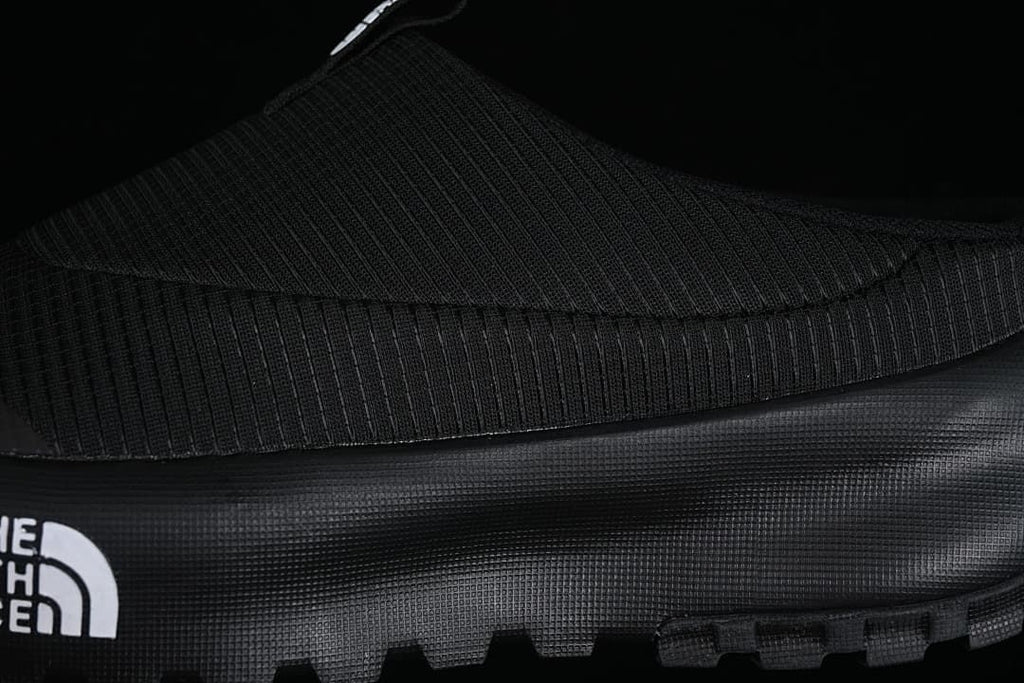Close-up of the ribbed black upper and textured sole sidewall