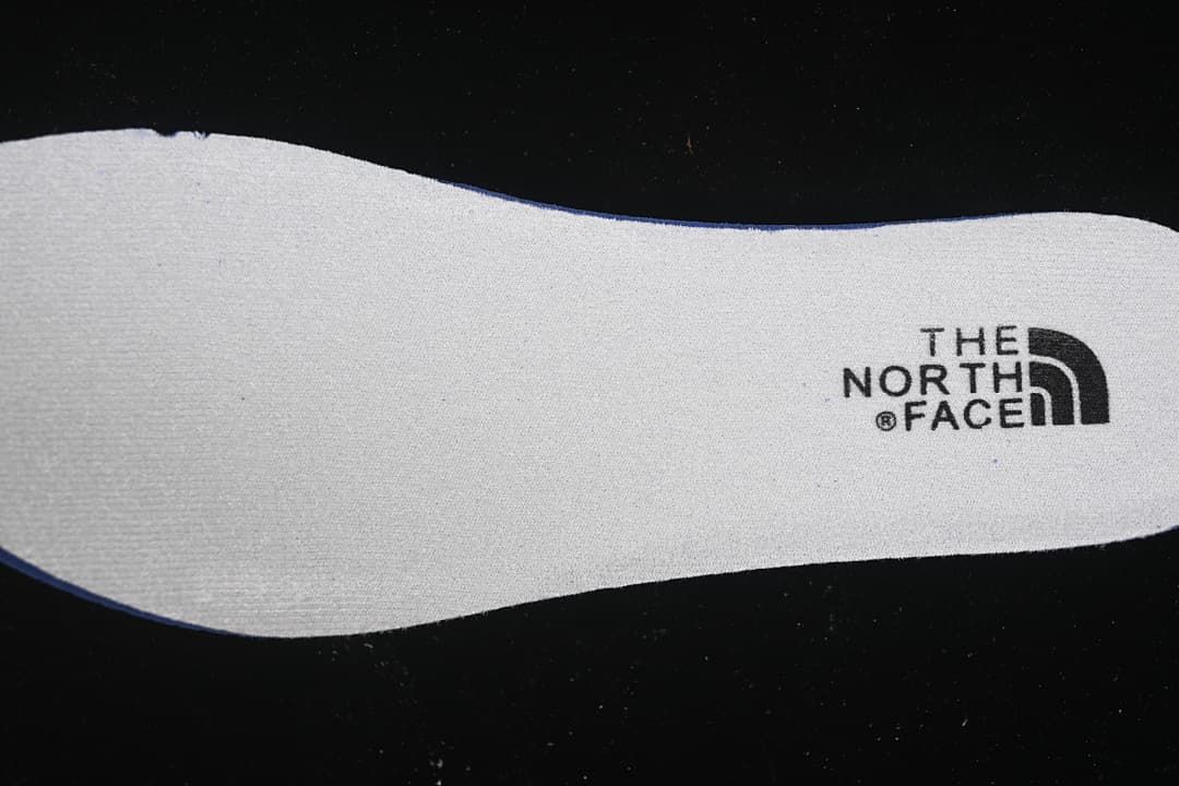 Close-up of a white insert bearing The North Face logo