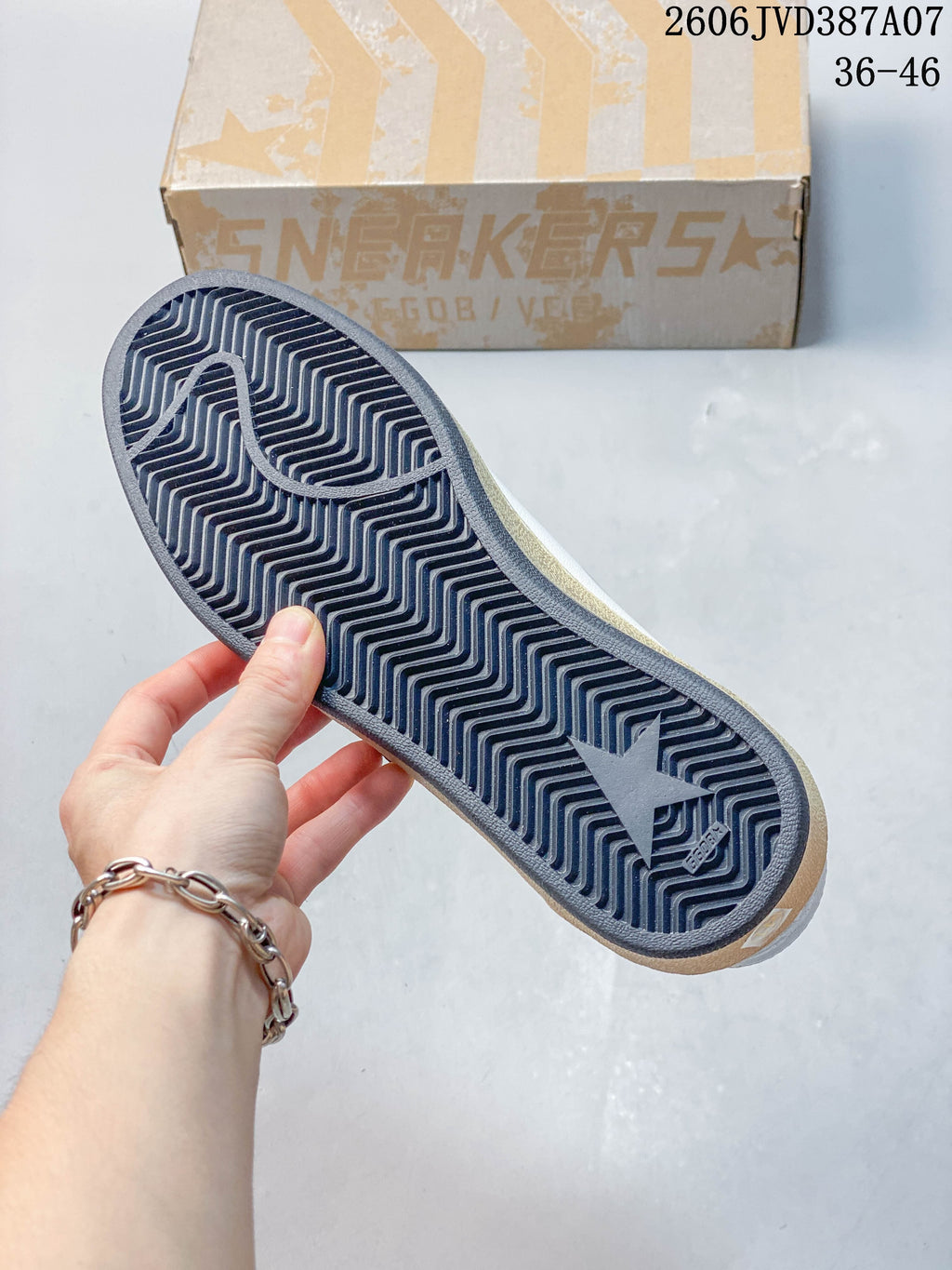 Outsole of the sneaker showing a dark zigzag tread and star motif