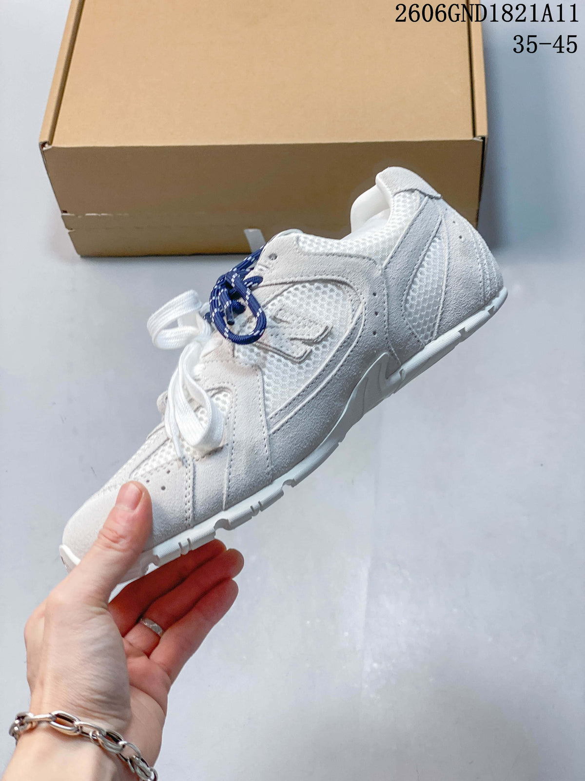Side view of a white and gray sneaker with layered panels and contrasting laces