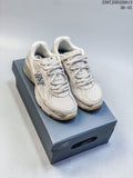 Pair of light neutral New Balance 740 sneakers shown on a shoebox