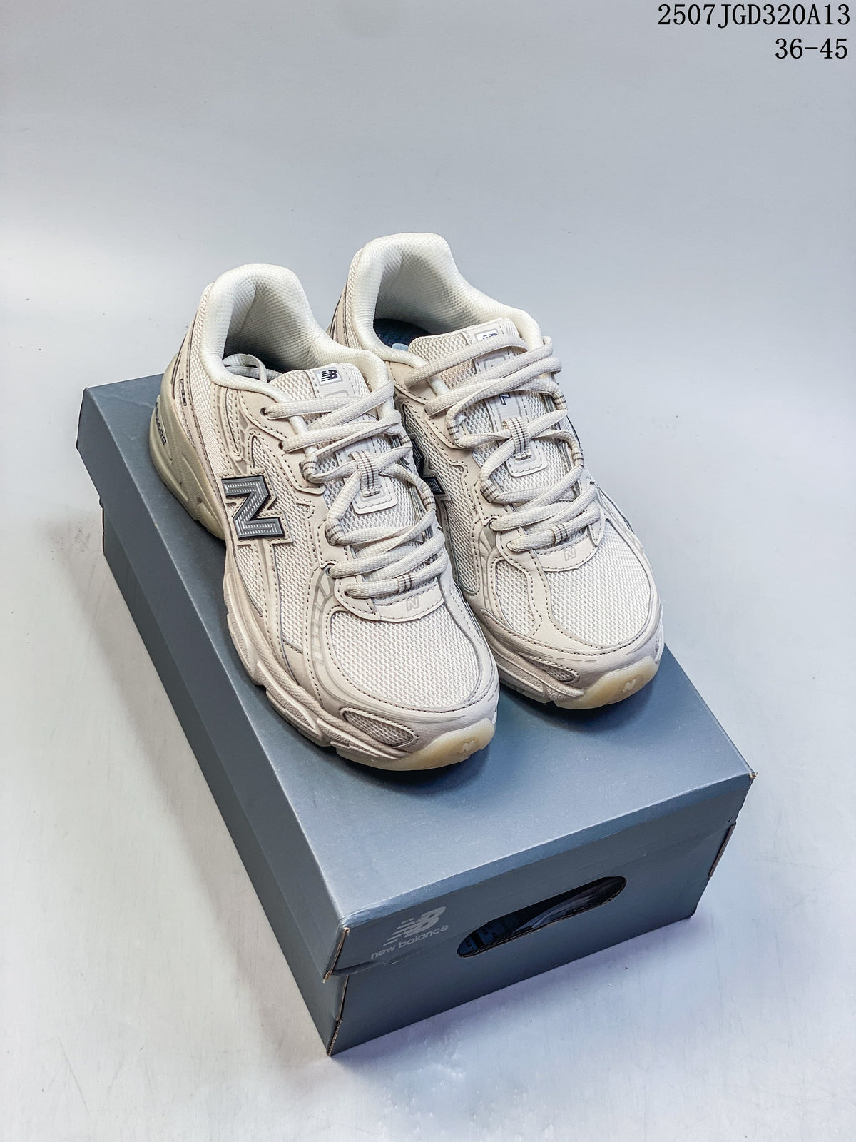 Pair of light neutral New Balance 740 sneakers shown on a shoebox