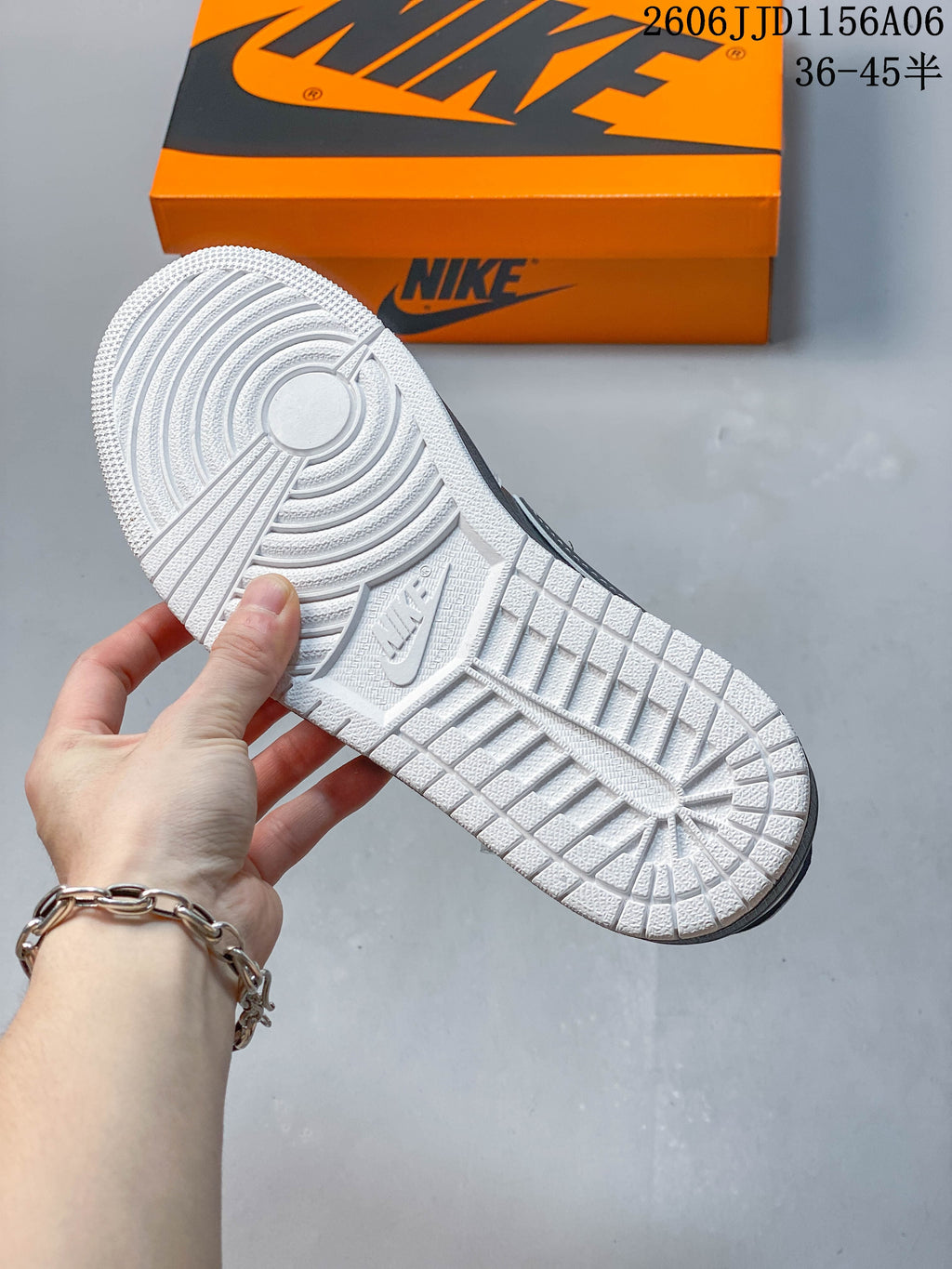Close-up of the white patterned outsole on a gray and white sneaker