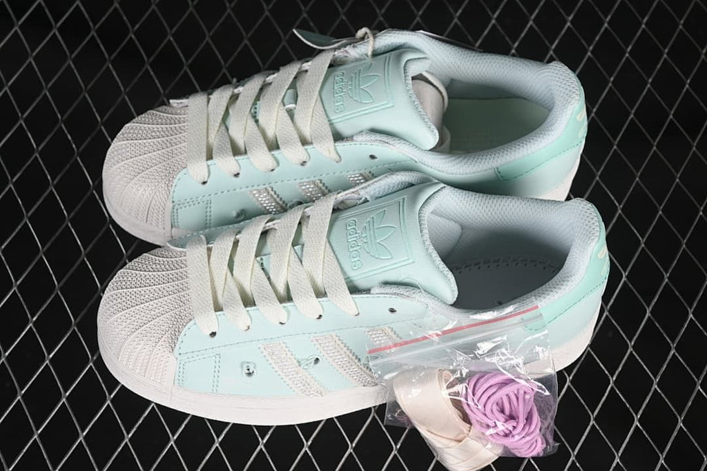 Pair of mint green Superstar II sneakers with spare laces
