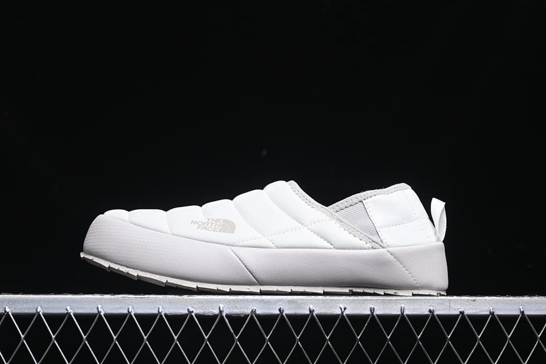 Side view of a white The North Face ThermoBall Traction mule slipper.