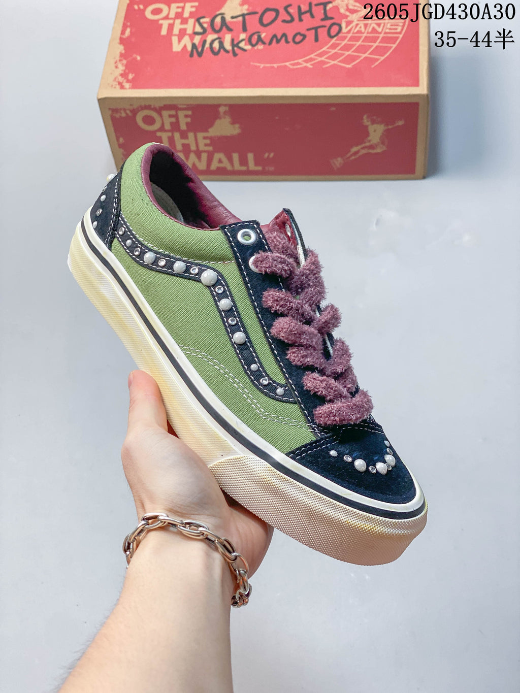 Angled side view of a green and navy Vans LX Old Skool sneaker with pearl-like accents and a cream-colored sole.