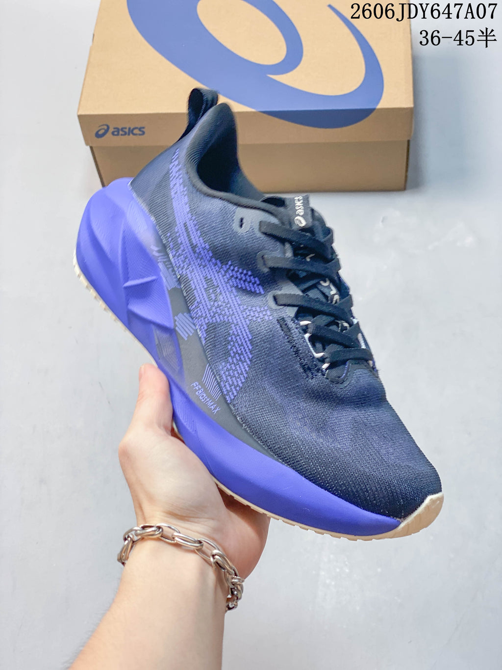 Angled side view of a navy and purple running shoe