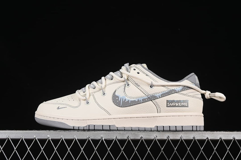 Side view of an off-white and gray low-top sneaker with a graphic Swoosh and heel pull loop