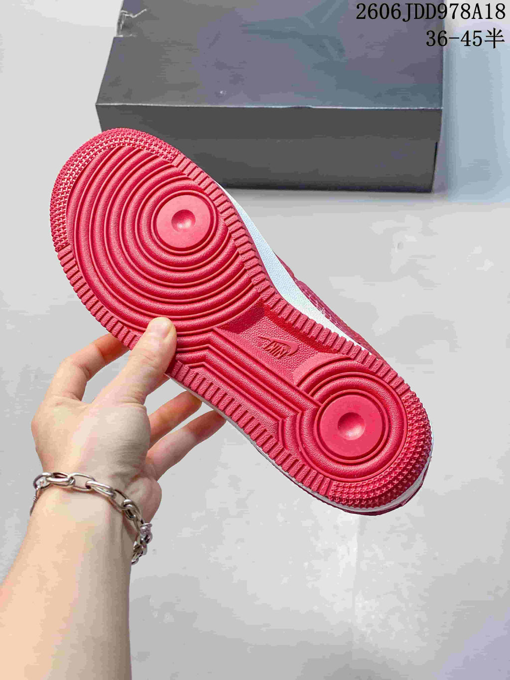 Underside of a red sneaker showing its circular outsole tread