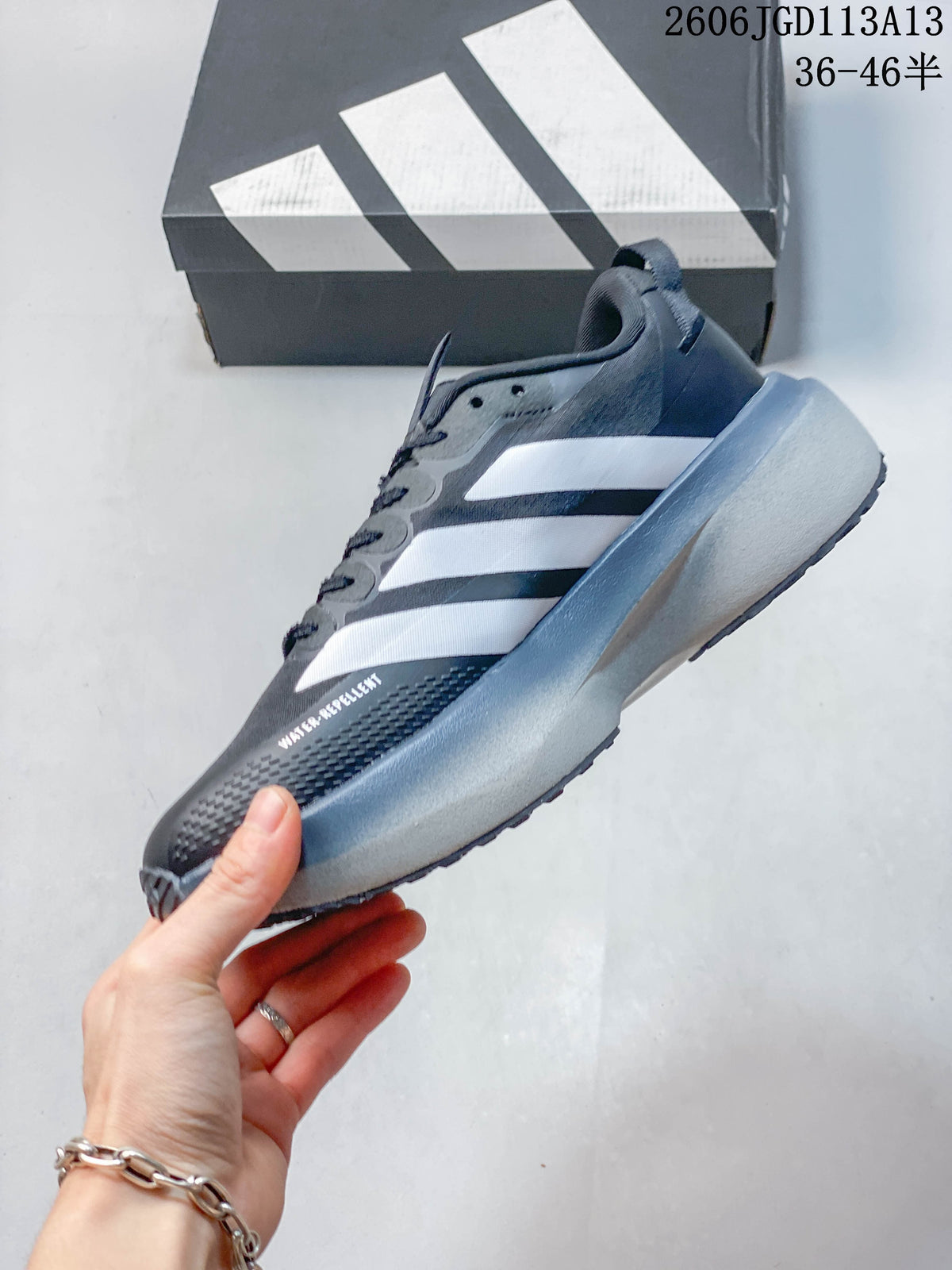 Side profile of a charcoal gray Adizero Evo SL ATR shoe with white stripes.
