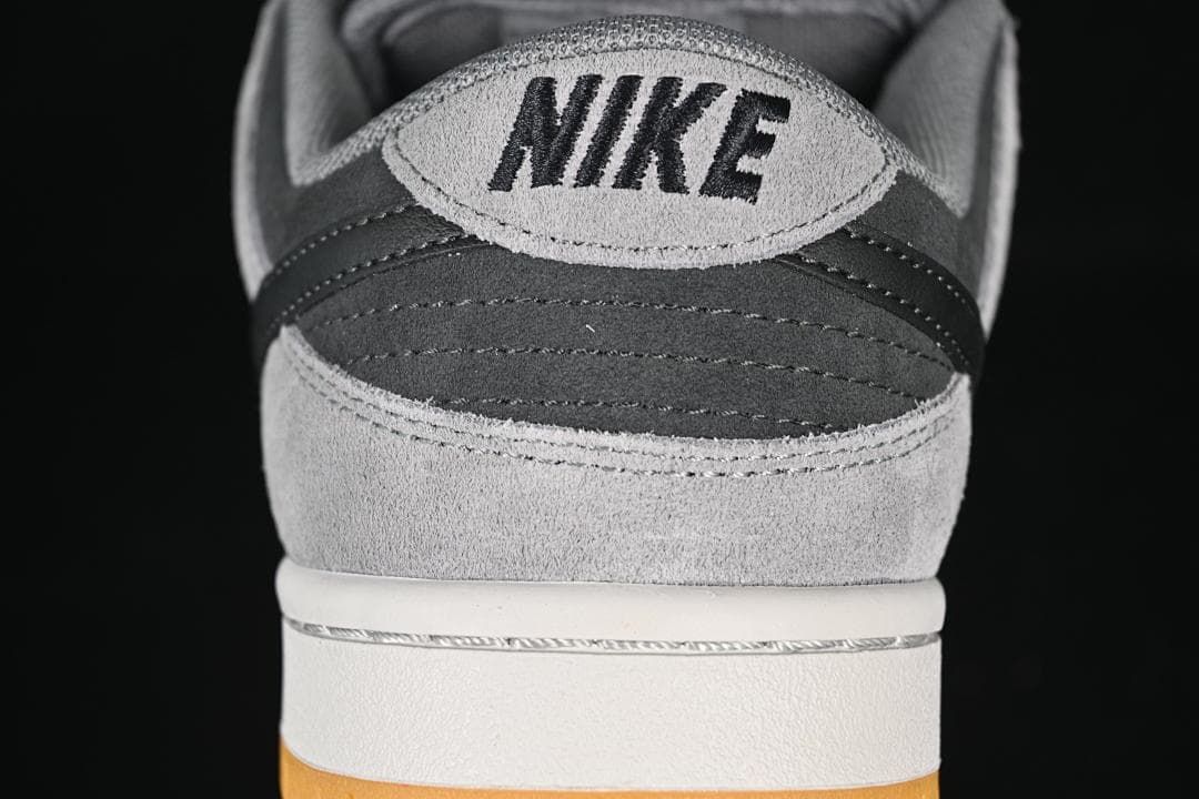 Rear view showing layered grey and black panels, Nike branding, and gum outsole