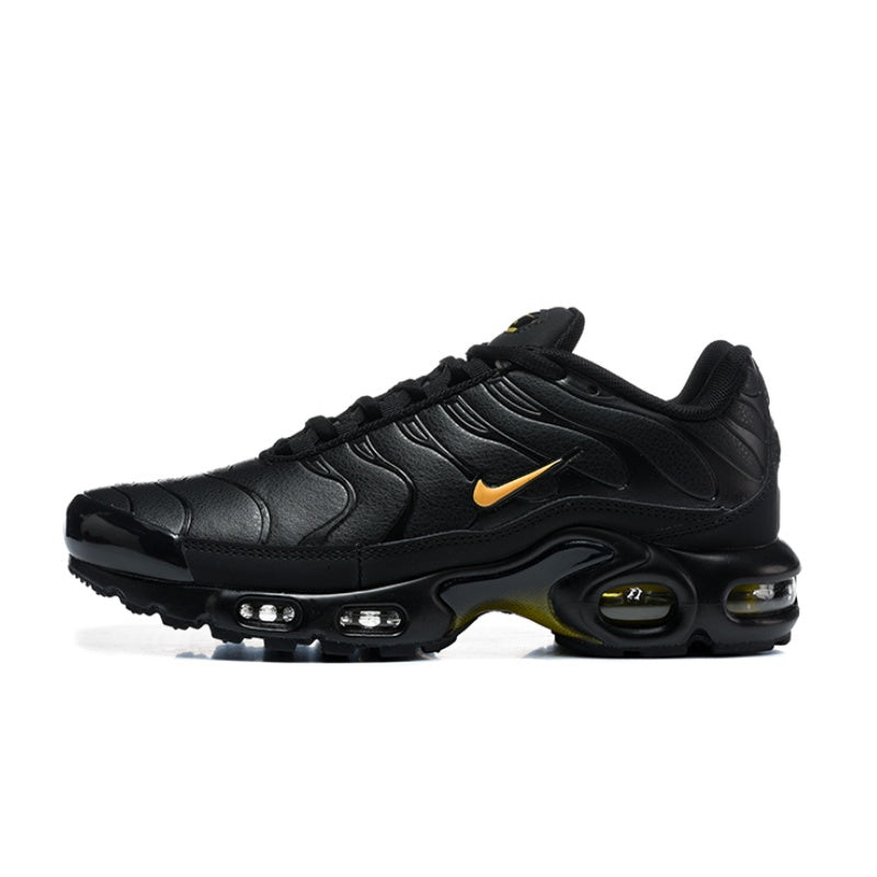 Black Nike Air Max Plus sneaker with a small yellow swoosh and visible air units.