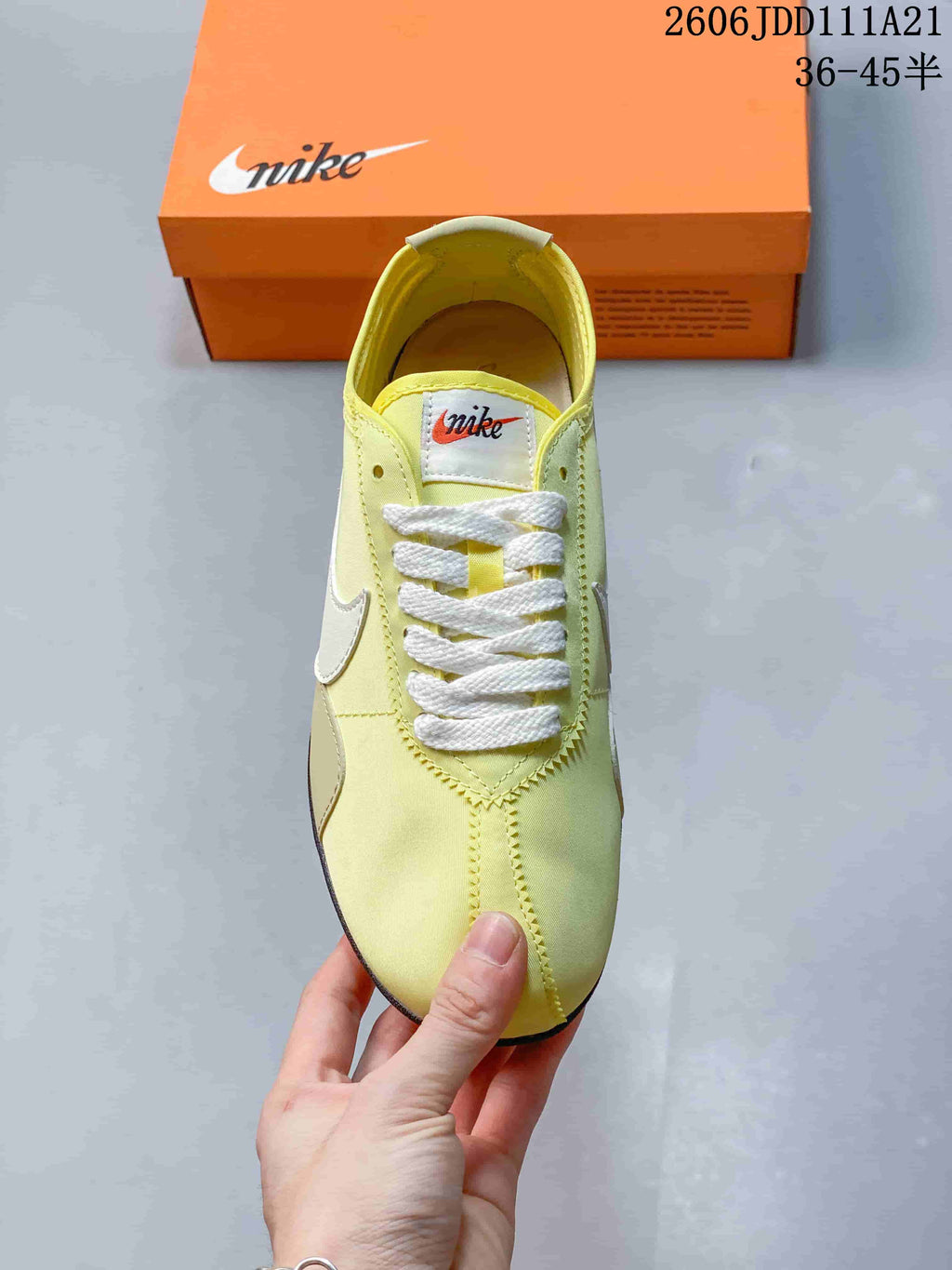 Top view showing the sneaker's pale yellow upper, white laces, and tongue label.