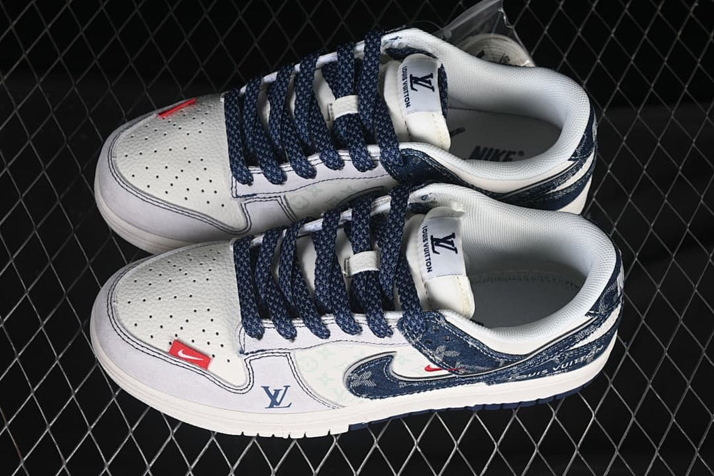Top view of a pair of off-white and navy low-top sneakers with dark laces, patterned panels, and red accents.