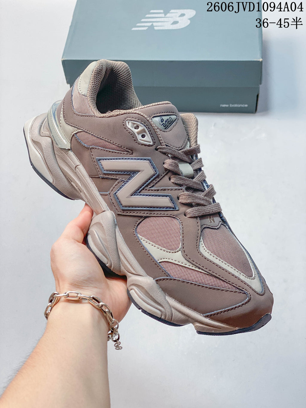 Angled side view of a taupe New Balance sneaker with a contrasting logo
