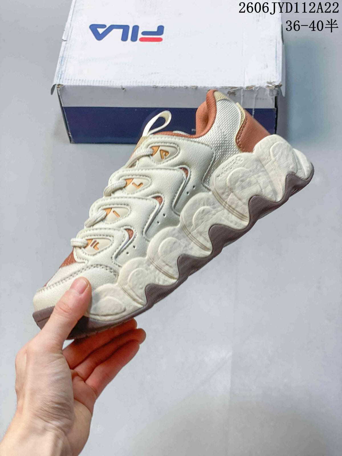 Side view of a cream chunky sneaker with rust accents
