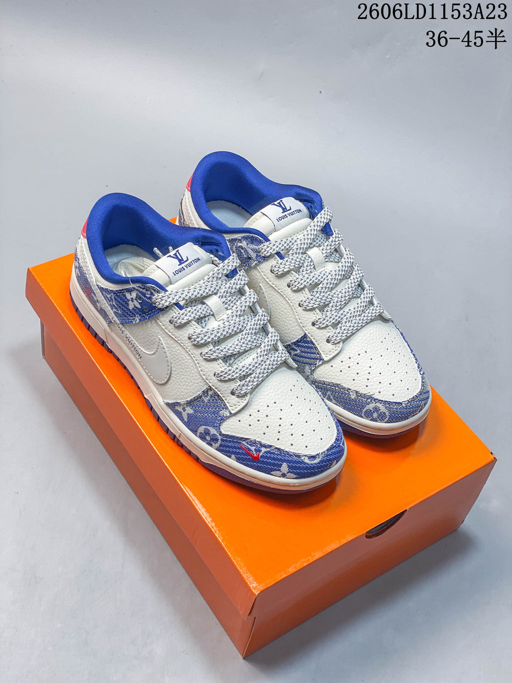 Pair of white low-top sneakers with blue patterned panels and bright blue collars