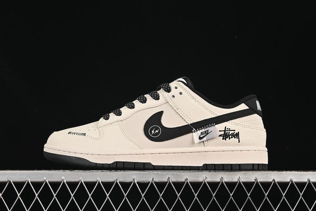 Side view of a cream and black low-top sneaker with graphic side accents