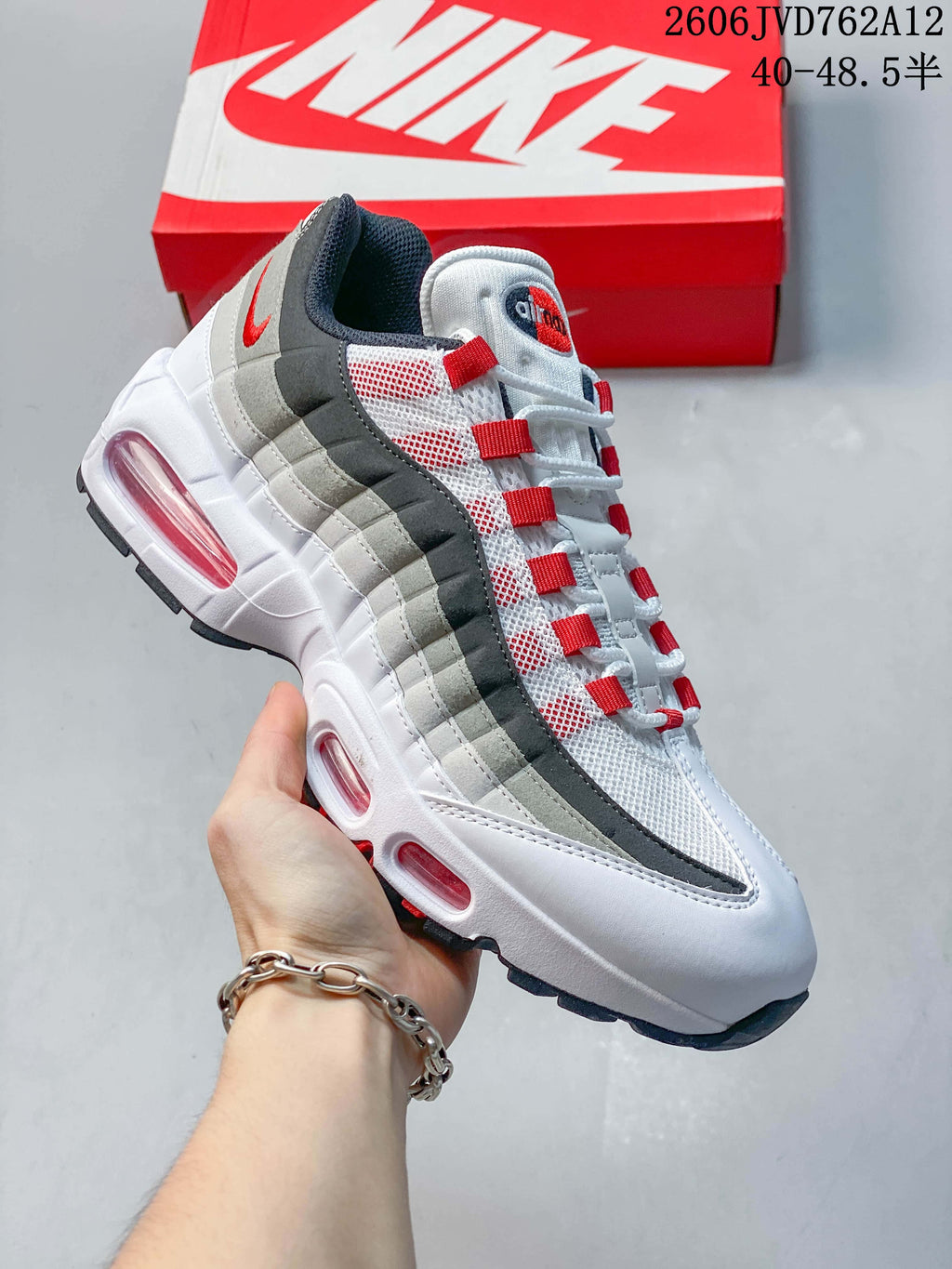 Angled side view of a Nike Air Max 95 OG sneaker in white, gray, and red.