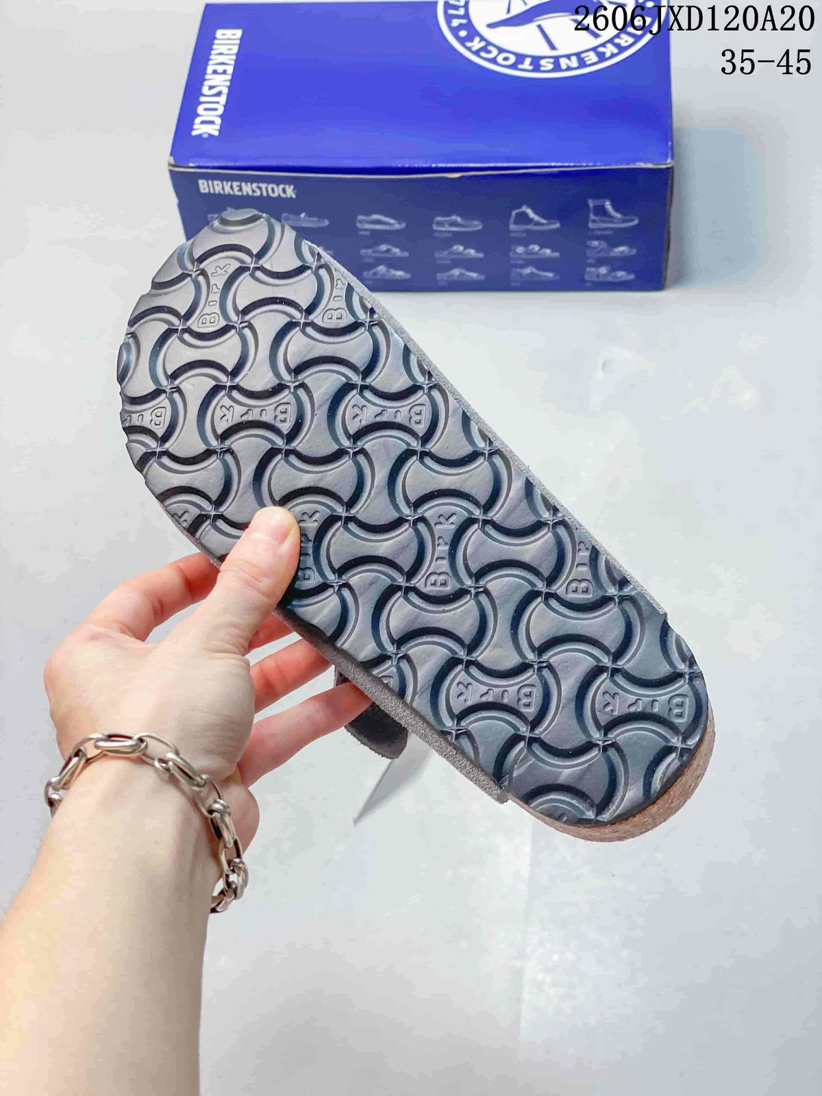 Close-up of the patterned outsole of a gray clog