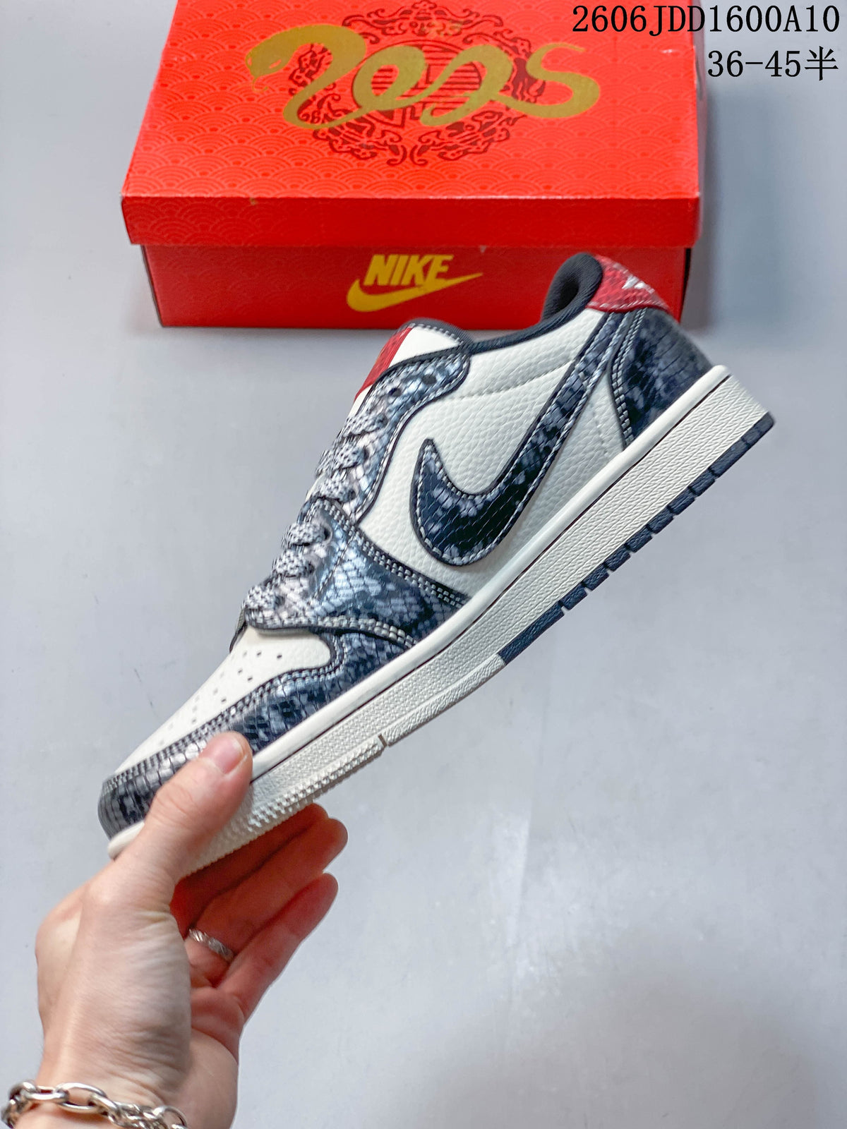 Side view of the low-top sneaker with dark patterned overlays and a prominent Swoosh