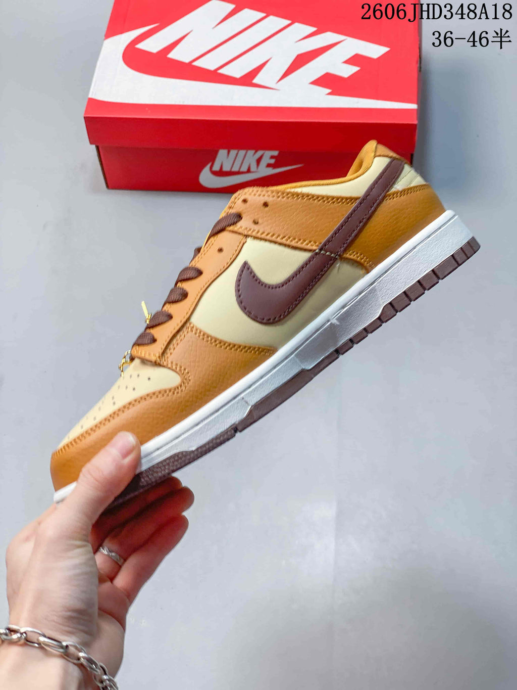 Side view of the brown and cream low-top sneaker with a dark-brown Swoosh.