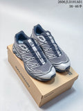 Pair of gray, black, and silver Salomon XT-6 sneakers displayed on a shoebox