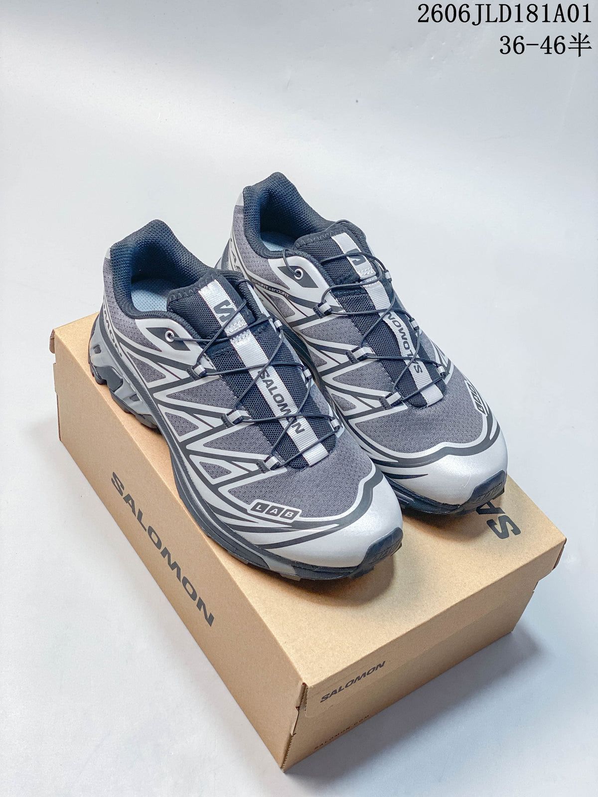 Pair of gray, black, and silver Salomon XT-6 sneakers displayed on a shoebox