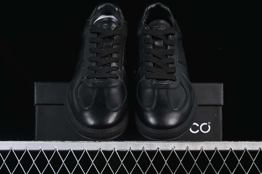 Front view of the pair of black sneakers on a shoe box