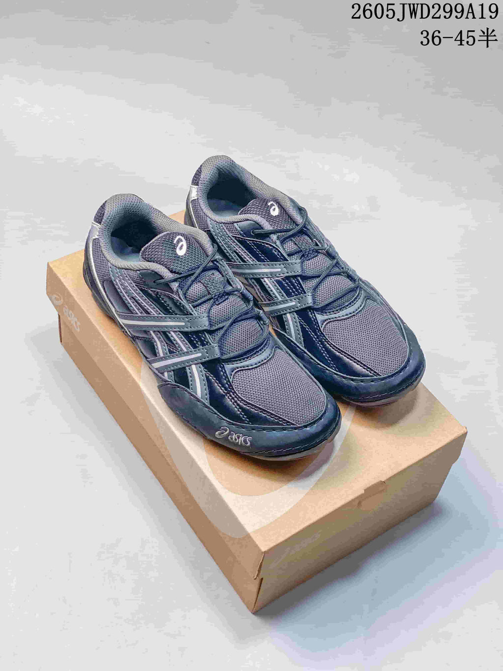 Navy and cream ASICS GEL-1130 sneakers shown together on a shoebox