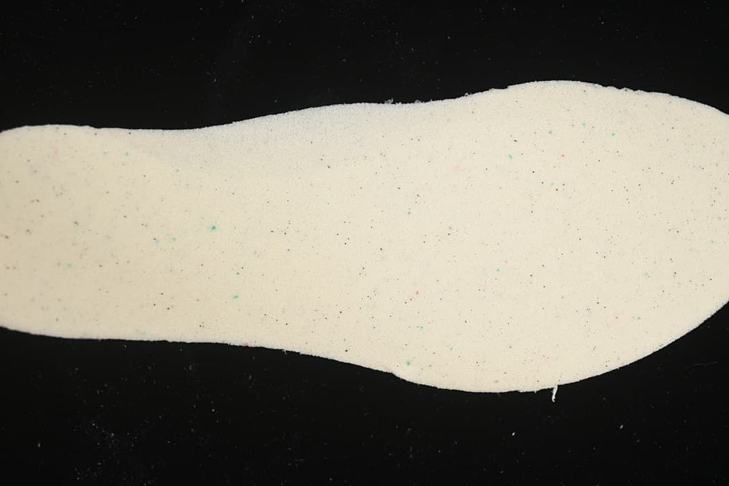 Light-colored shoe insole shown against a dark background