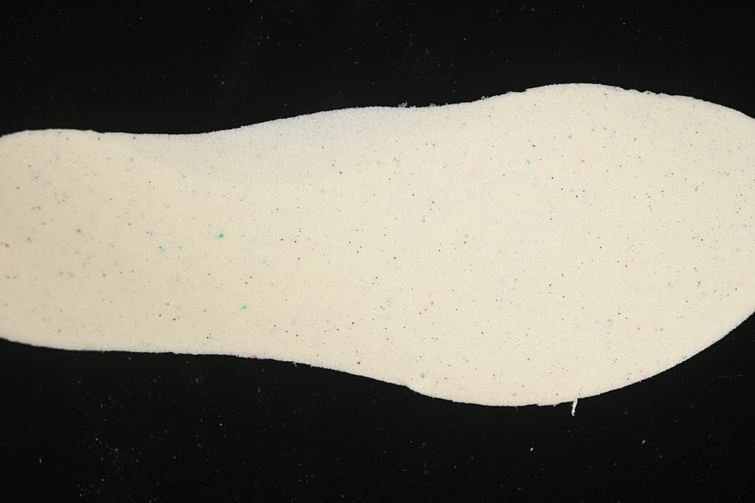 Light-colored shoe insole shown against a dark background