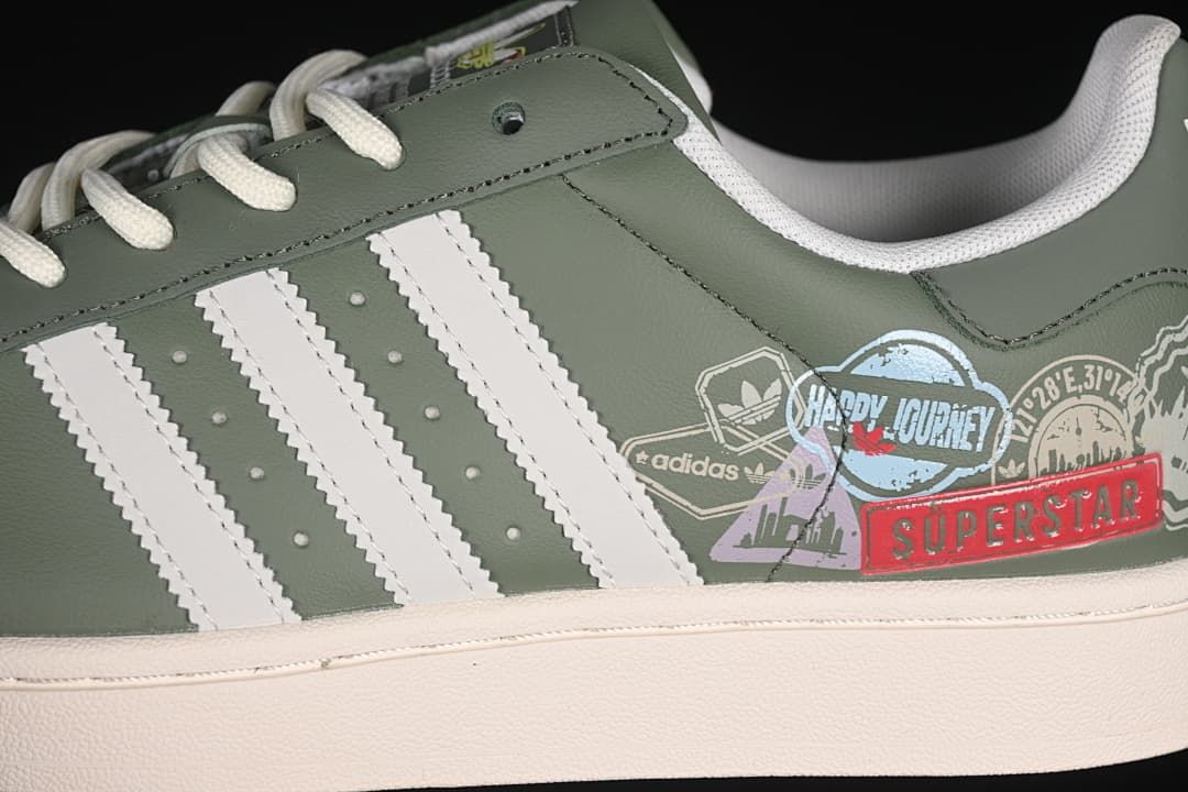 Close-up of the white stripes and printed graphics on the green sneaker side.