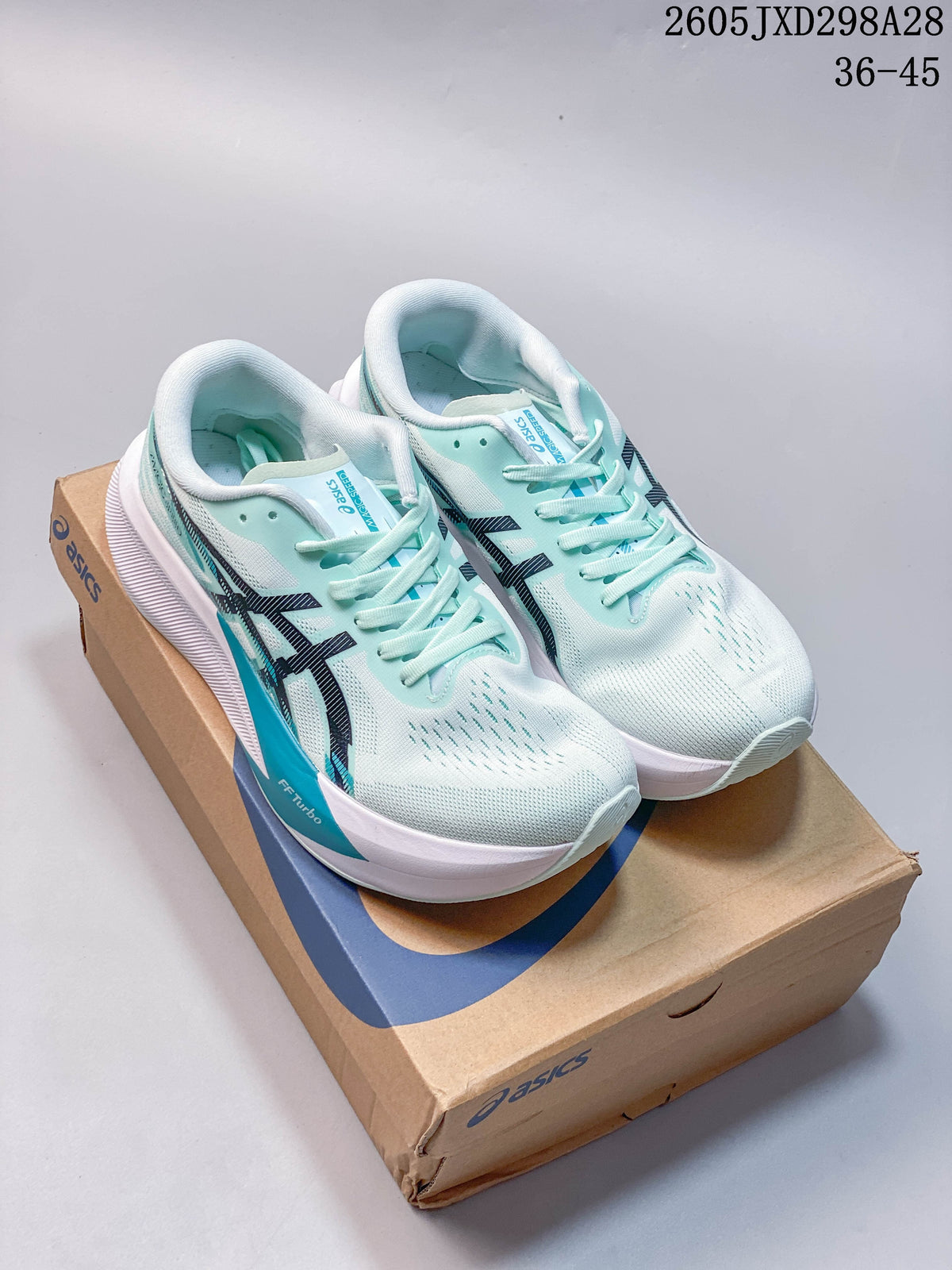 Pair of mint ASICS MAGIC SPEED 4 running shoes on a shoebox