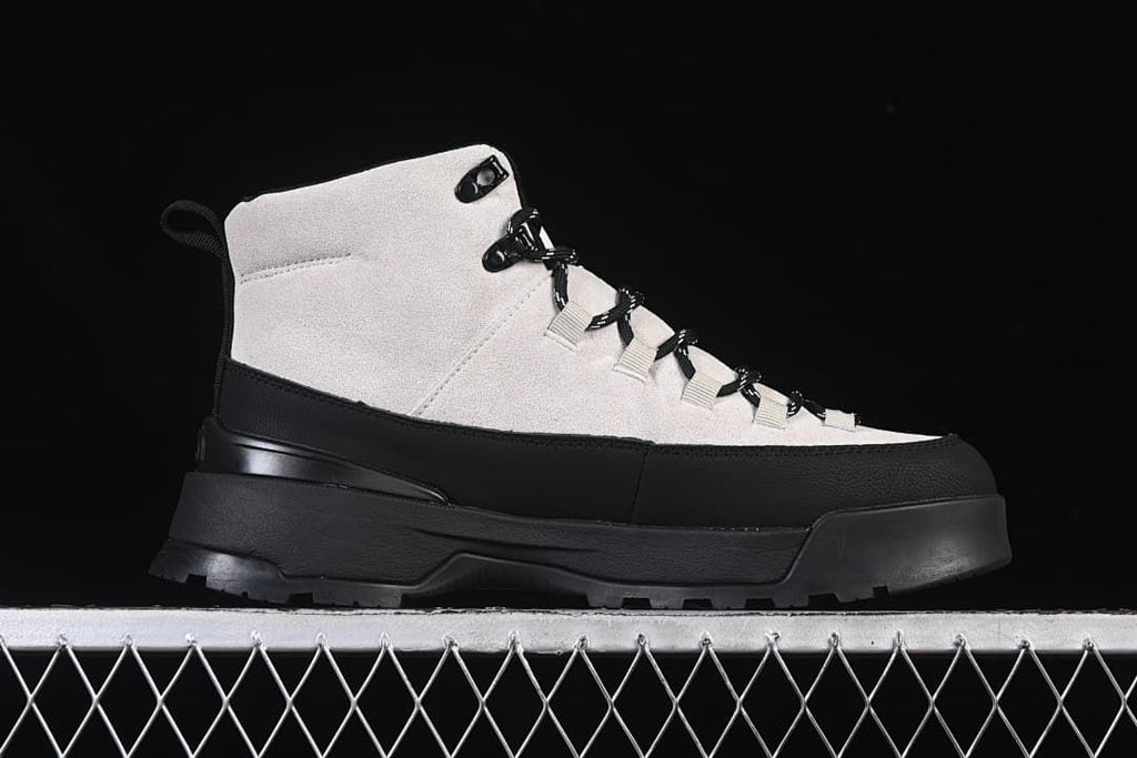 Side profile of a light and black mid-height boot