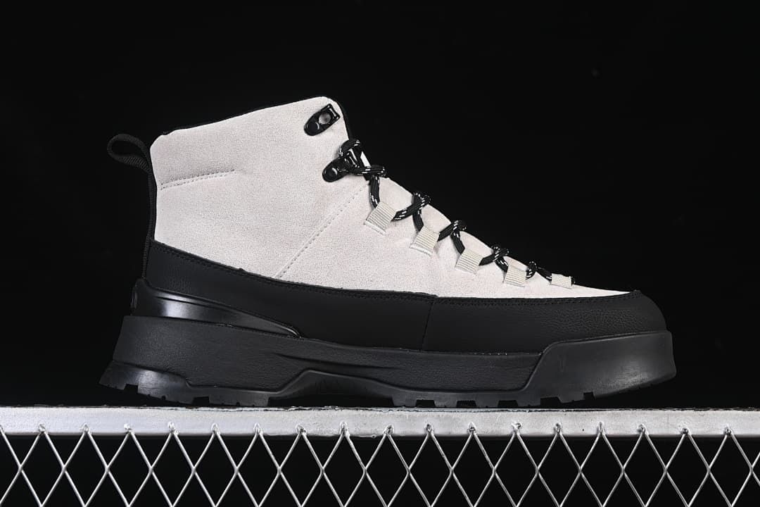 Side profile of a light and black mid-height boot