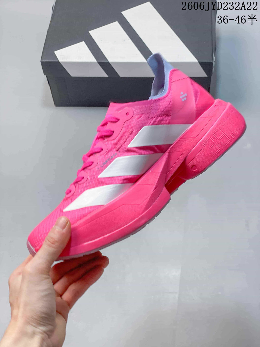 Side view of a pink running shoe with white stripes and a sculpted sole.