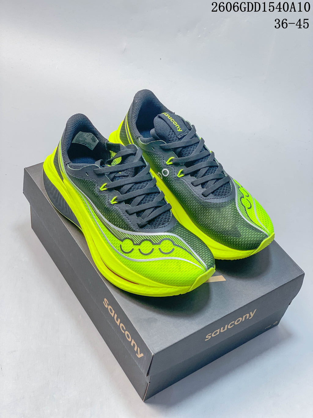 Pair of charcoal and neon yellow Saucony Endorphin Pro 5 running shoes shown from above on a shoe box.