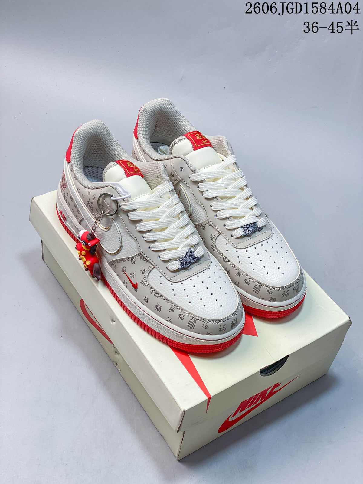 Angled view of off-white and gray low-top sneakers with red accents, character graphics, and a hanging charm