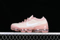 Side view of a light pink and cream Nike Air VaporMax shoe with a white Swoosh and transparent pink-toned sole.