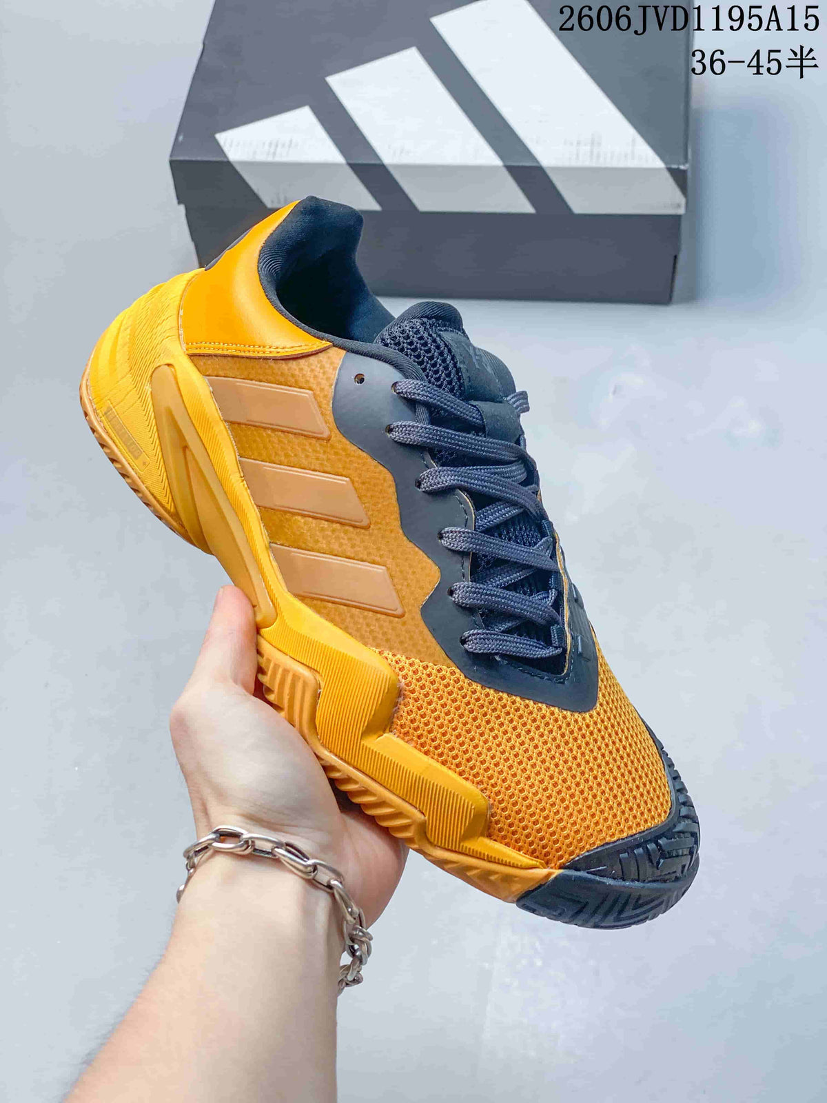 Side view of an orange and dark gray Y-3 Barricade 13 sneaker.