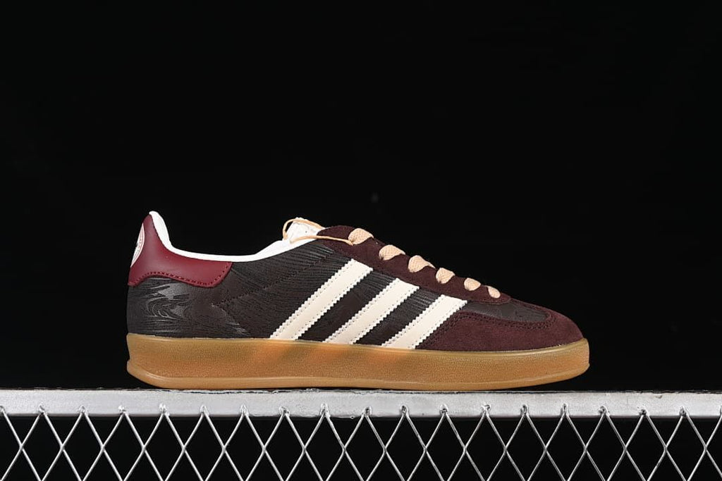 Side profile of the low-top sneaker showing its burgundy, dark brown, and off-white color blocking.