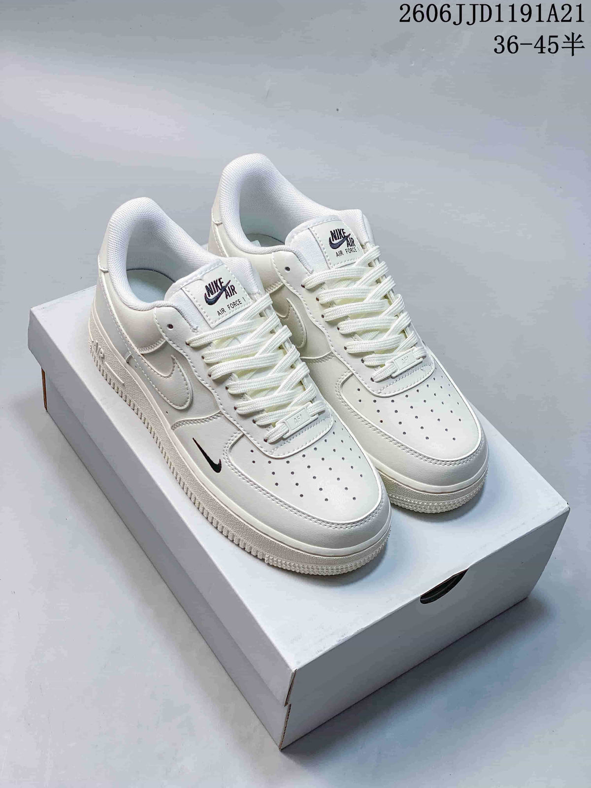 Pair of white low-top sneakers with small dark Swoosh accents and perforated toe boxes.