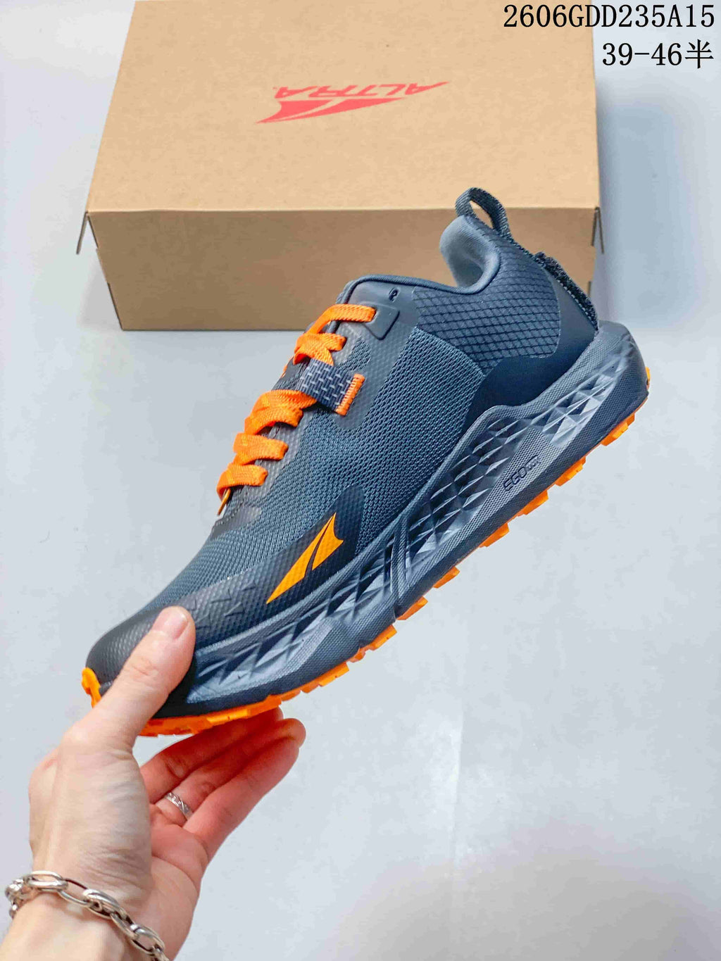 Side view of the gray Altra trail shoe with orange accents.