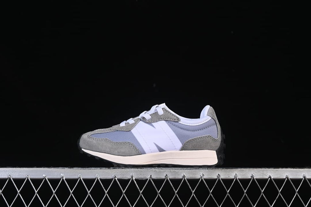 Side view of a grey, white, and muted blue New Balance 327 kids sneaker.