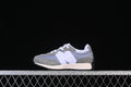Side view of a grey, white, and muted blue New Balance 327 kids sneaker.