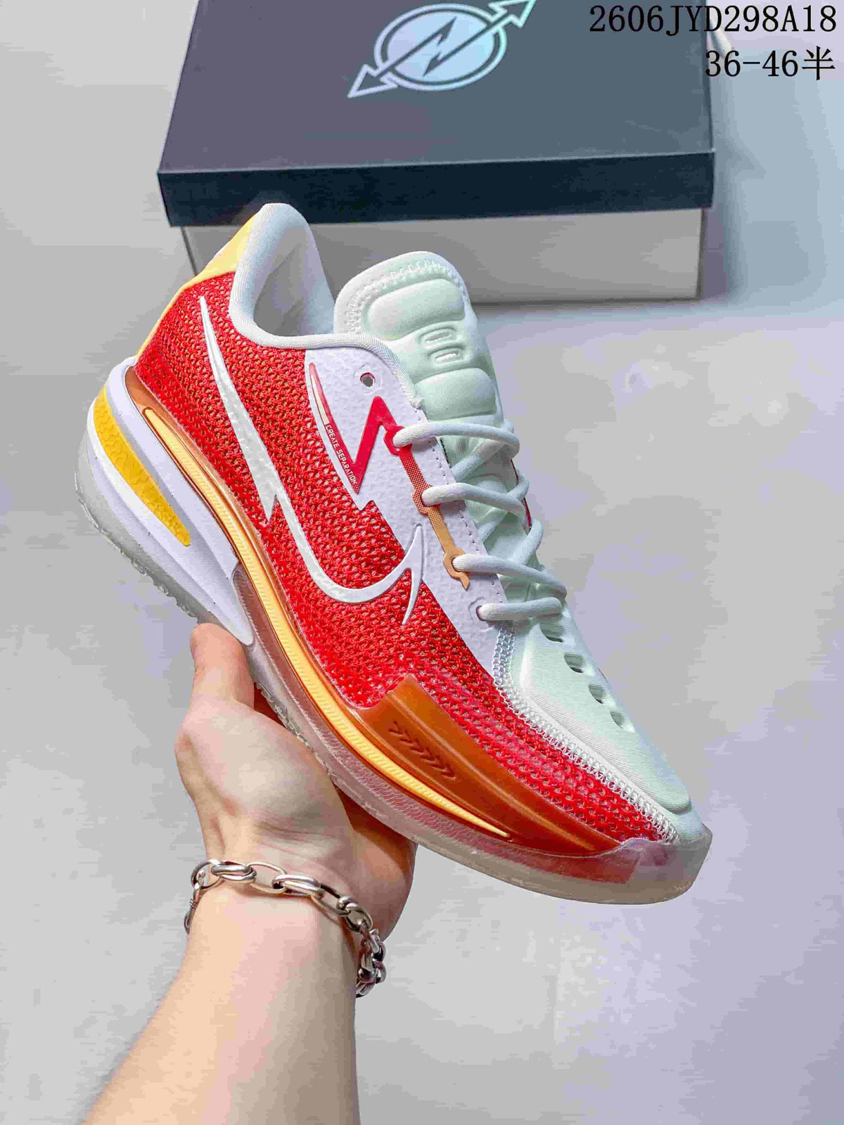 White and red Nike Air Zoom GT Cut low-top shoe with orange and gold accents.