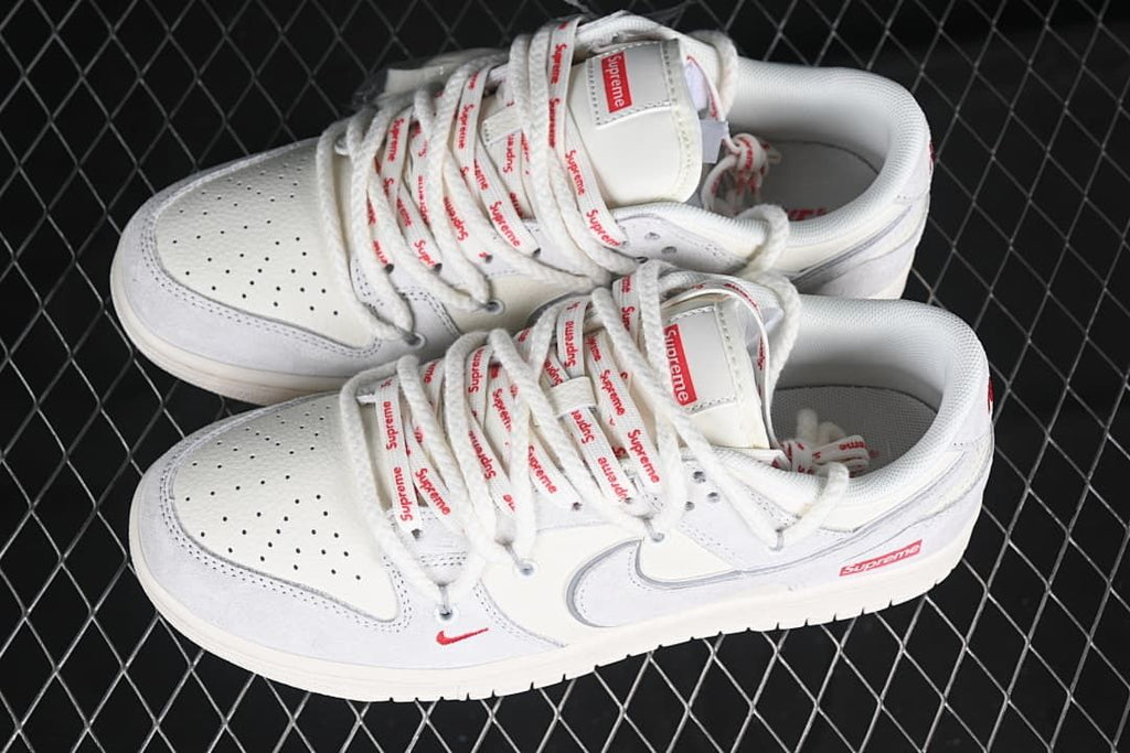 Pair of white and light gray sneakers with red details